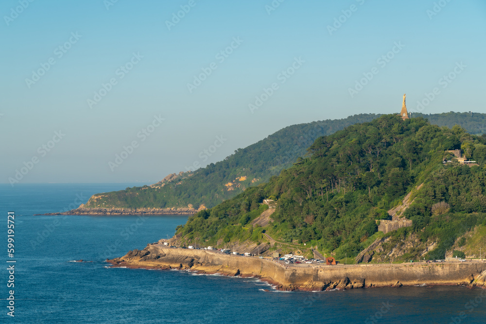 Santa Clara Island in the middle of La Concha Bay. Beautiful travel destination in north of Spain. Jesus Christ Statue on top of the hill. Touristic destination in north of Spain, Basque Country