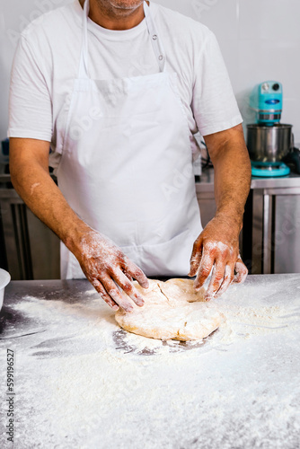 Baker kneading flour for bread making