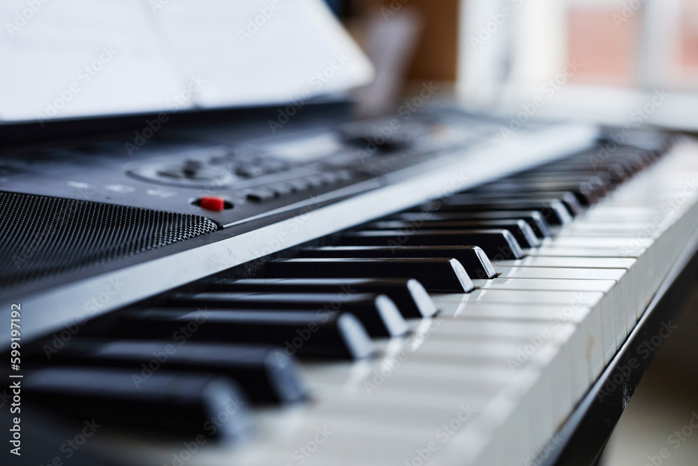 Close-up of synthesizer with sheet music for playing music in class Close-up of synthesizer with sheet music for playing music in class