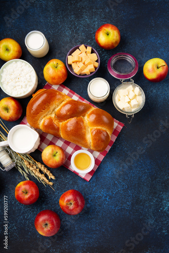 Jewish Shavuot Holiday Card. Dairy Products, Apples, Cheese, Bread, Milk on Blue Wooden Background.