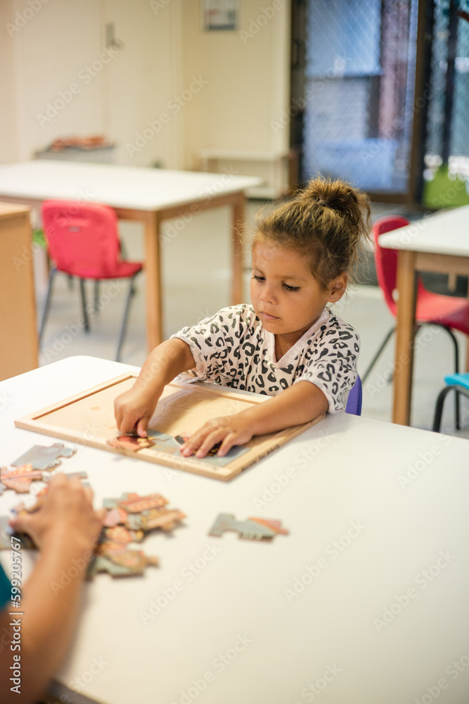 Young Aboriginal girl at preschool doing a puzzle Young Aboriginal girl at preschool doing a puzzle