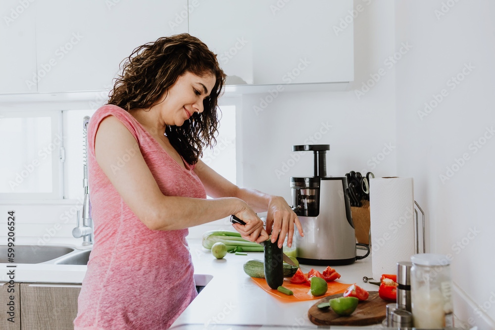 Latin adult woman preparing salad bowl in the kitchen at home in Mexico, Hispanic female in Latin America Latin adult woman preparing salad bowl in the kitchen at home in Mexico, Hispanic female in Latin America