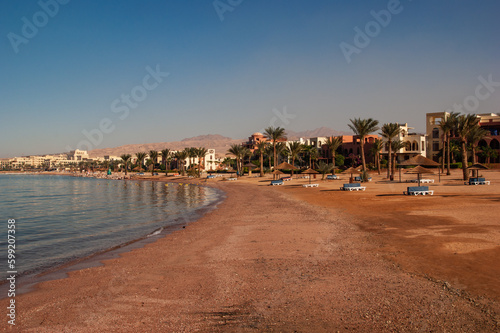 Hotel Movenpick Resort and SPA Tala Bay Aqaba 5 stars on the Red Sea in Jordan. Coastline with sandy beaches. Beach umbrellas and sun loungers between palm trees.Aqaba, Jordan - December 06, 2009 © MarinoDenisenko
