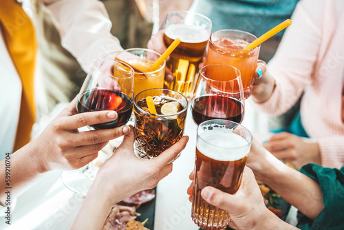 Close up image of hands holding cocktail glasses at bar restaurant - Young people having fun hanging out on weekend day - Food and beverage concept with guys and girls drinking alcohol together