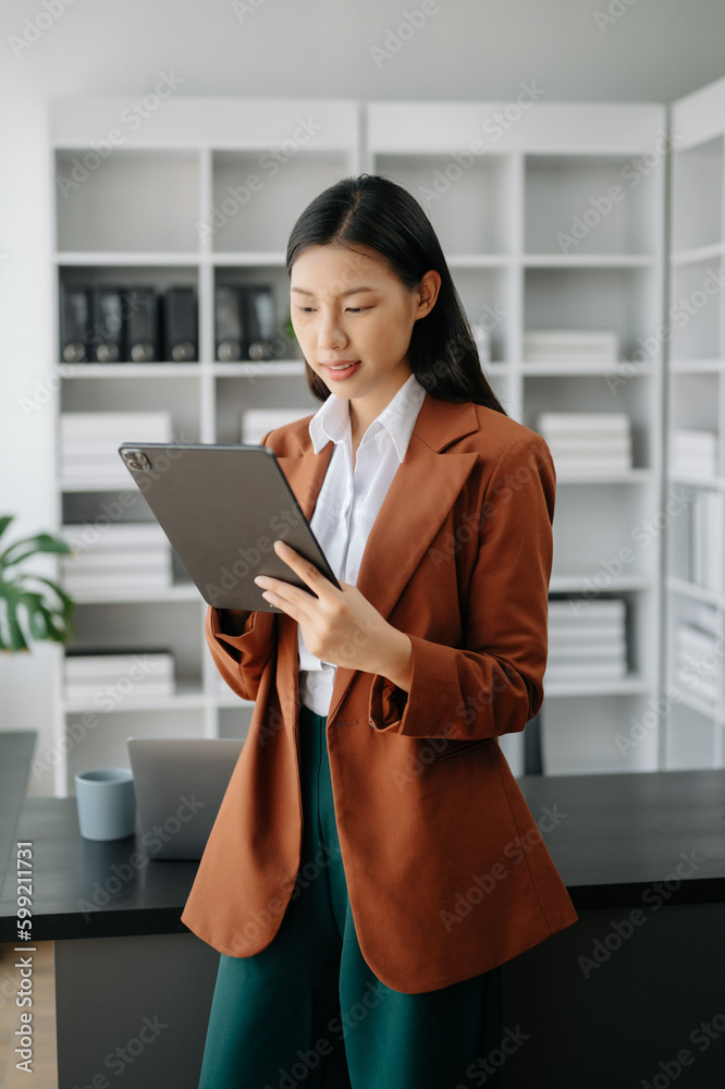 Business woman using tablet and laptop for doing math finance on an office desk, tax, report, accounting, statistics, and analytical research concept in office Business woman using tablet and laptop for doing math finance on an office desk, tax, report, accounting, statistics, and analytical research concept in office