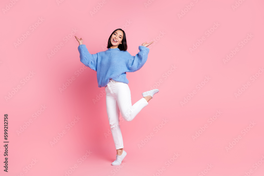 Full size portrait of overjoyed positive girl stand one leg raise hands empty space isolated on pink color background Full size portrait of overjoyed positive girl stand one leg raise hands empty space isolated on pink color background