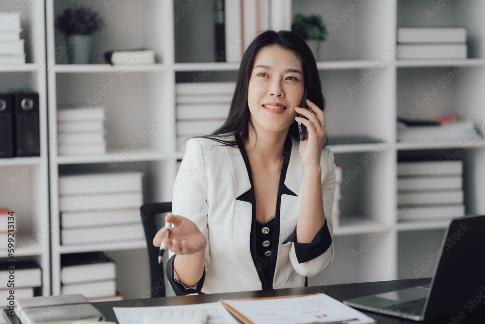 Cheerful business lady working on laptop in office, Asian happy beautiful businesswoman in formal suit work in workplace. Attractive female employee office worker smile. Cheerful business lady working on laptop in office, Asian happy beautiful businesswoman in formal suit work in workplace. Attractive female employee office worker smile.