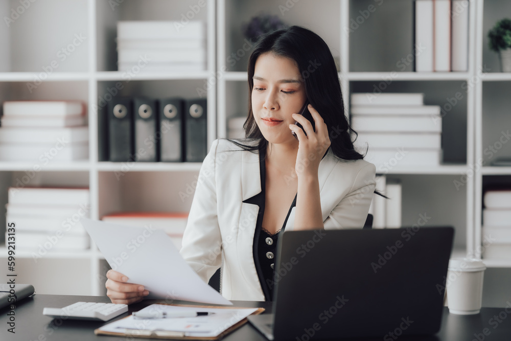 Cheerful business lady working on laptop in office, Asian happy beautiful businesswoman in formal suit work in workplace. Attractive female employee office worker smile. Cheerful business lady working on laptop in office, Asian happy beautiful businesswoman in formal suit work in workplace. Attractive female employee office worker smile.