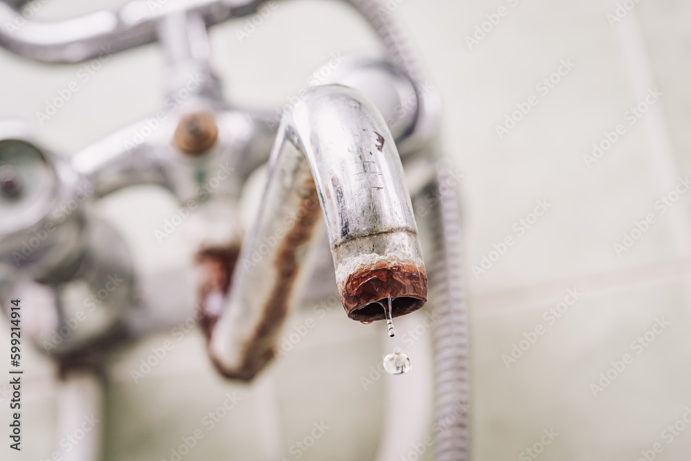 Old bathroom faucet with water drop. Tap covered in rust, lime layer, toned photo - obrazy, fototapety, plakaty 