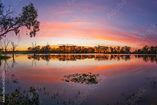 A dramatic dawn sky reflected in the waters of a still river photo