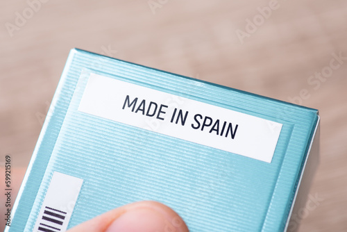 Made in Spain inscription on blue paper box of perfume, close up. Manufacturing goods of high quality in Europe concept