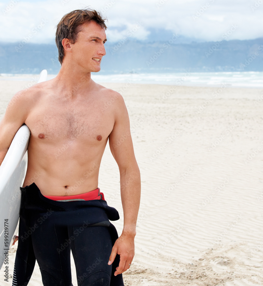 Surfing is a way of life. A young male surfer getting ready to go for a surf on a hot summers day.
