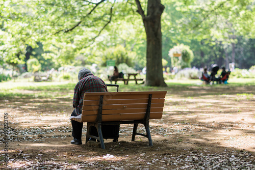 公園のベンチにひとりで座る男性高齢者