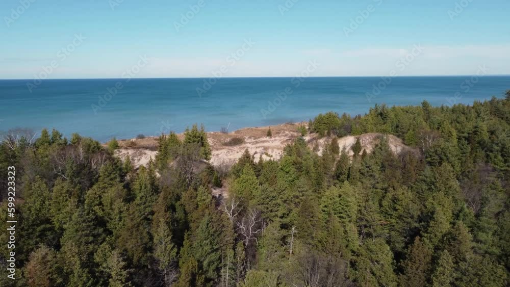Flying Above Trees In Autumn Foliage Towards Dunes Area On The Shores Of Lake Huron Near Pinery Provincial Park In Ontario, Canada. aerial descend Flying Above Trees In Autumn Foliage Towards Dunes Area On The Shores Of Lake Huron Near Pinery Provincial Park In Ontario, Canada. aerial descend