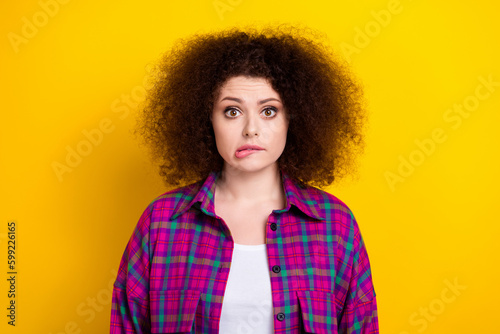 Closeup photo of unhappy nervous panic frightened young lady wear violet plaid trendy shirt bite lips oops failed isolated on yellow color background