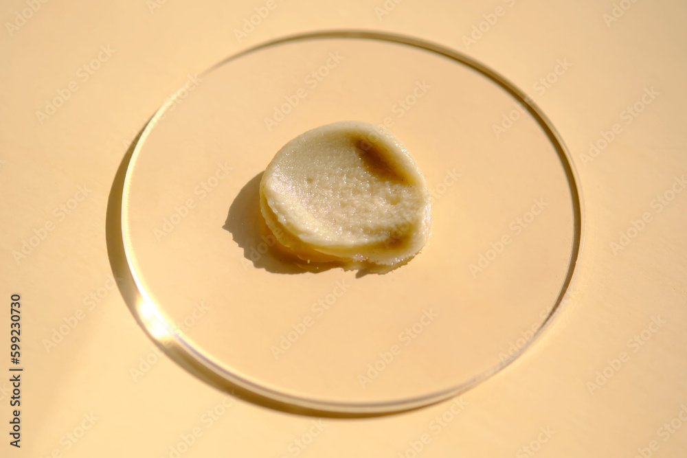 Facial peeling drop swatch on a beige background.