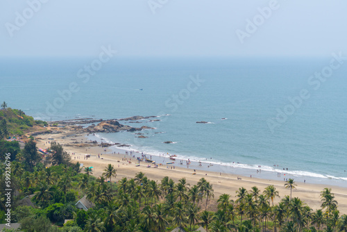 Wide angle shot of Vagator beach as seen from the top of the Chapora Fort at Goa in India. Wide angle shot of beach as seen from above. Blue sea in goa. Summer relaxation background.  photo