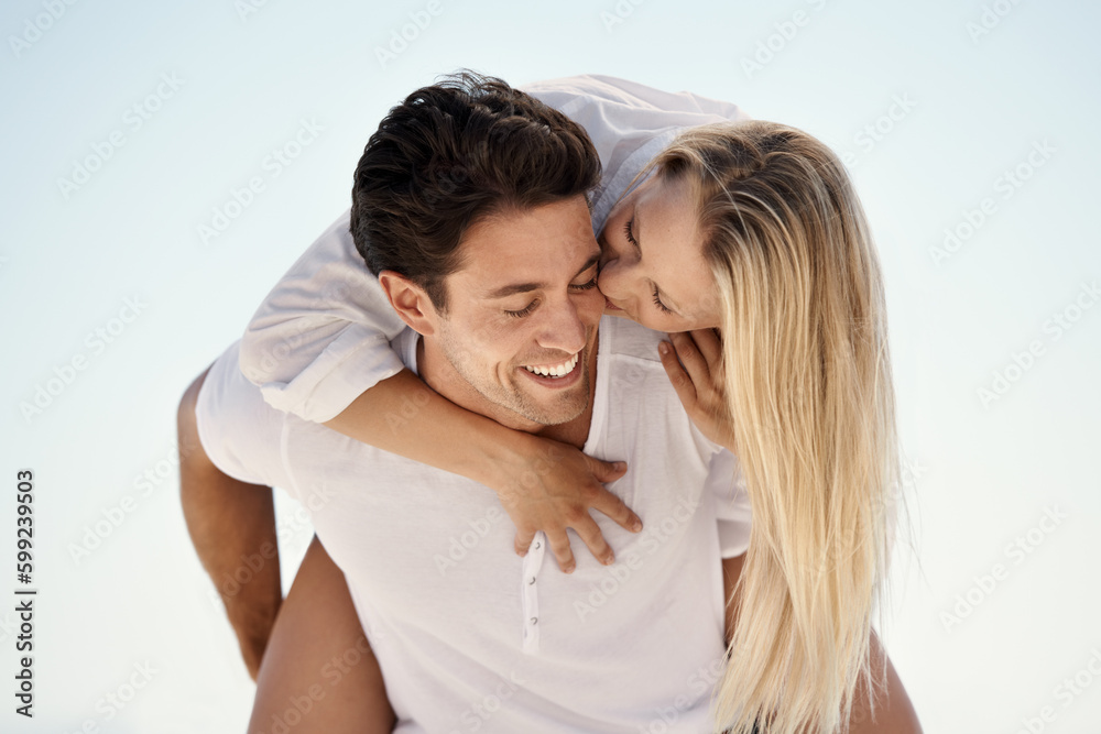 Playful Summer Romance. A handsome young man giving his girlfriend a piggyback ride outside. Playful Summer Romance. A handsome young man giving his girlfriend a piggyback ride outside.