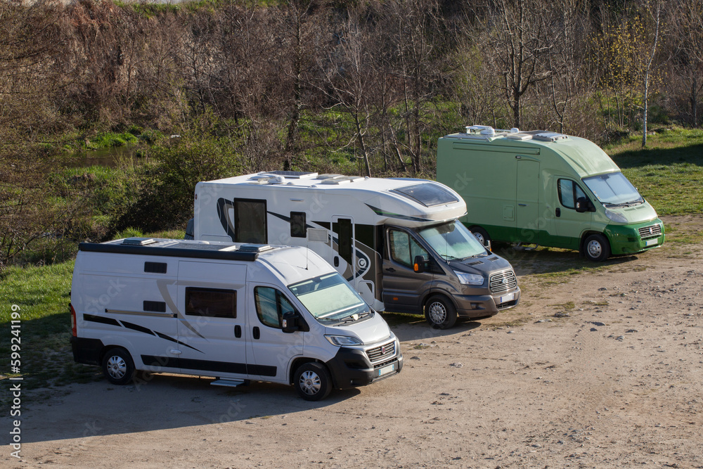 Trois camping-cars en stationnement sur une place