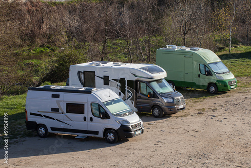 Trois camping-cars en stationnement sur une place