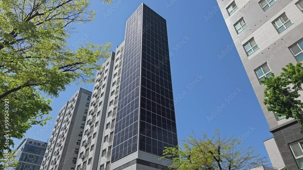 Towering Solar-Clad Skyscraper Against Blue Sky In Seoul's Skyline In South Korea. low angle, tilt-up Towering Solar-Clad Skyscraper Against Blue Sky In Seoul's Skyline In South Korea. low angle, tilt-up