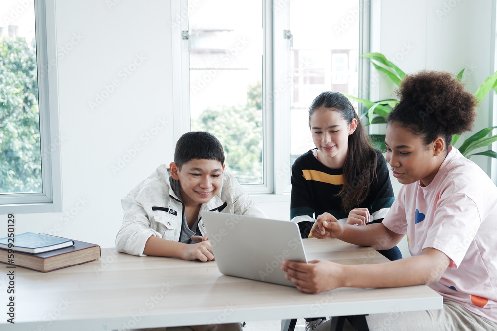 Smiling Caucasian and African student is online learning and make homework for home school. They are researching knowledge with internet on laptop in classroom. Education and Technology Concept.