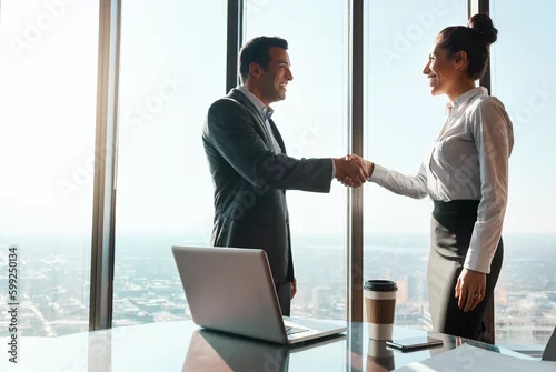 Obraz Im glad we could reach an agreement. two businesspeople shaking hands in an office.
