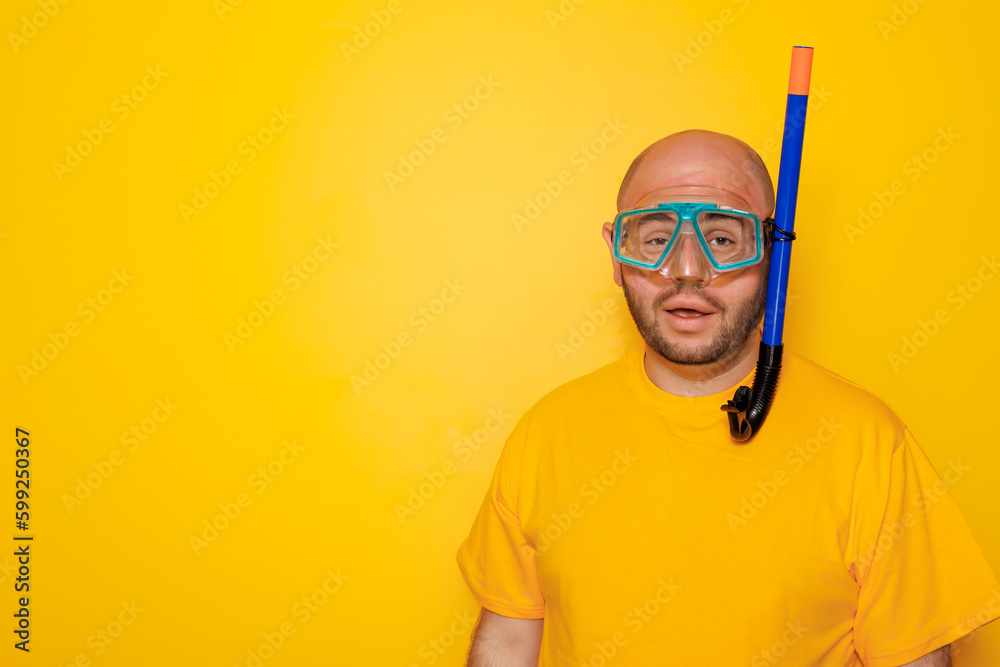 Man wearing snorkeling mask on yellow colored background