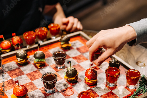 Drunken checkers. men play checkers with shot alcoholic drinks and mini burgers