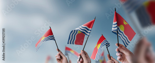 A group of people holding small flags of the Kiribati in their hands