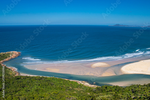A beautiful blue river going into the ocean viewed from above. Guarda do Embaú, Santa Catarina, Brazil. photo