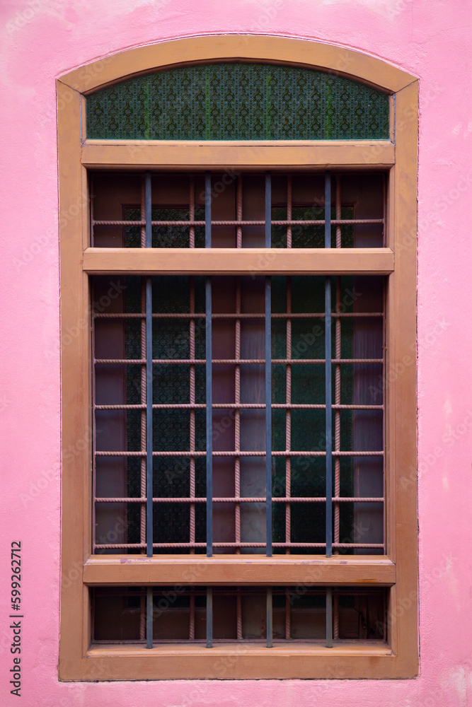 The pink color cement wall with old window, living house architecture detail.