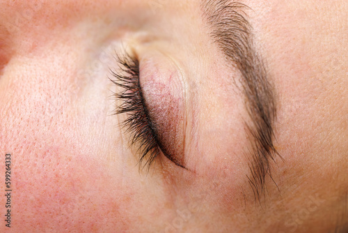 Closed eyelid. Permanent make-up of the eyelids, eyelash tattooing. photo