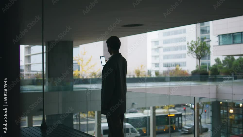 Woman silhouette using mobile phone at urban view. Relaxed businesswoman scroll Woman silhouette using mobile phone at urban view. Relaxed businesswoman scroll