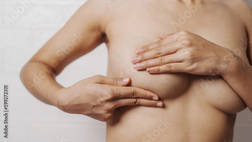 Young asian woman examining breast mastopathy or signs of breast cancer, Closeup Sexy Topless Naked Female With Breast Cancer Awareness