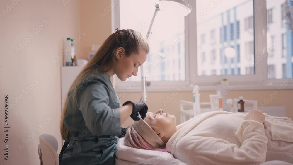 Beautician making botulinum toxin injection to senior woman, mesotherapy Beautician making botulinum toxin injection to senior woman, mesotherapy
