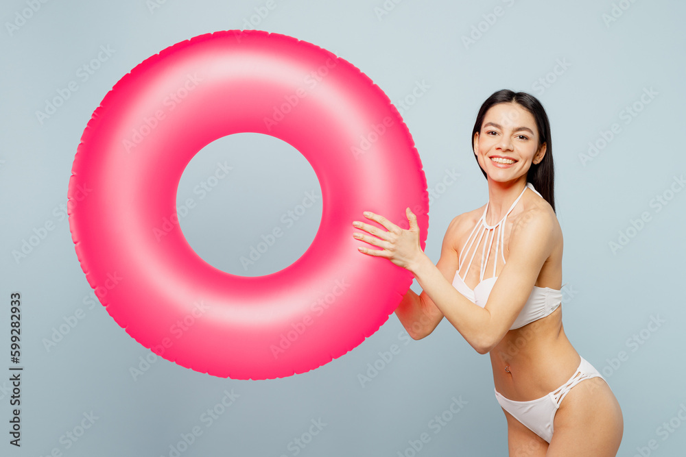 Cheerful teen girl posing in pink bikini in studio isolated on