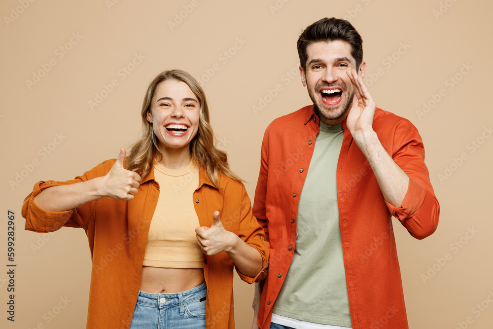 Young couple two friends family man woman wear casual clothes scream share hot news about sales discount hands near mouth together show thumb up isolated on pastel plain light beige color background Young couple two friends family man woman wear casual clothes scream share hot news about sales discount hands near mouth together show thumb up isolated on pastel plain light beige color background
