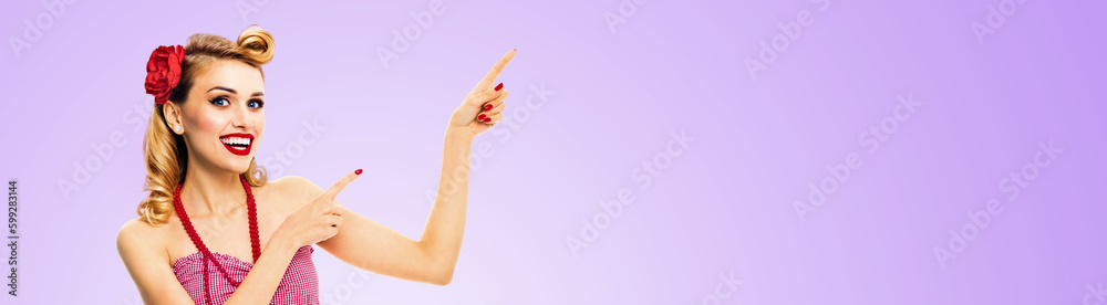 Photo of happy excited smiling woman pointing ad. Blond girl in pin up style, show, advertising copy space. Retro fashion and vintage. Isolated light purple violet background. Wide banner. Photo of happy excited smiling woman pointing ad. Blond girl in pin up style, show, advertising copy space. Retro fashion and vintage. Isolated light purple violet background. Wide banner.