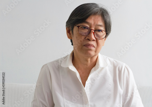 Portrait of old lady with wrinkle on her face,wearing glasses,looking with sadness eyes,