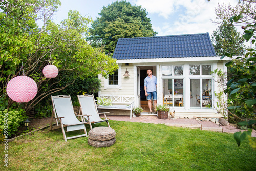 Portrait of man standing in doorway of house photo