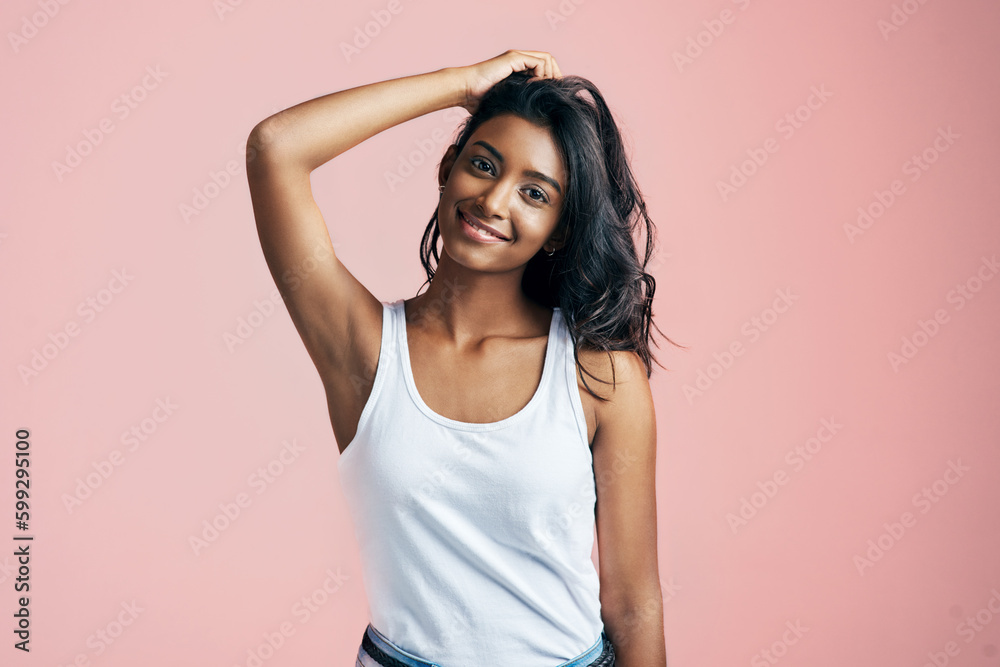 Isnt she lovely. Studio portrait of a beautiful young woman posing with her hand in her hair against a pink background. Isnt she lovely. Studio portrait of a beautiful young woman posing with her hand in her hair against a pink background.