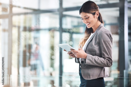 Doing business in the digital age. a young businesswoman using a digital tablet in a modern office.