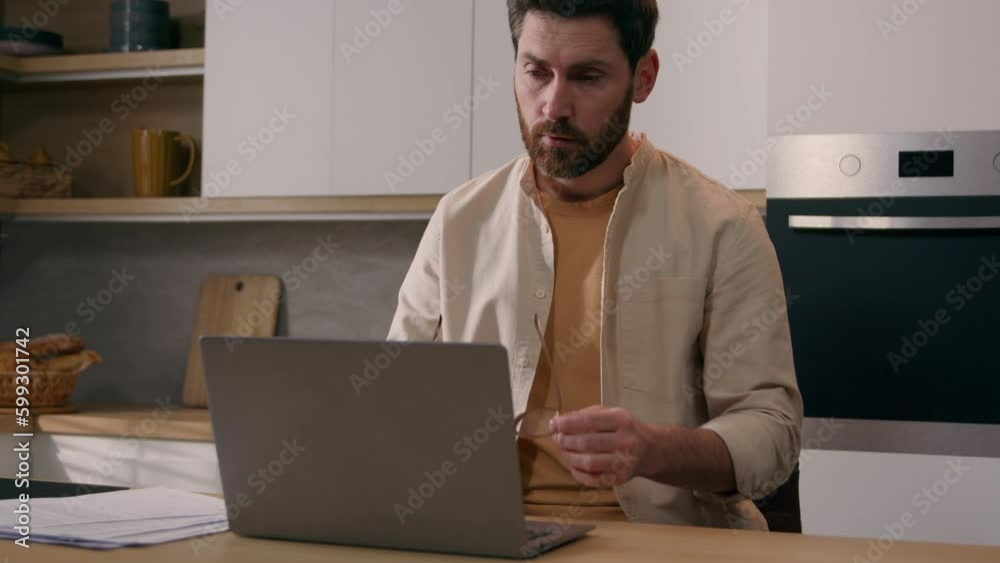 Caucasian tired exhausted man rubbing eyes feeling eyestrain discomfort put on glasses working laptop online distant job at home kitchen freelancer male with computer work paperwork internet payment