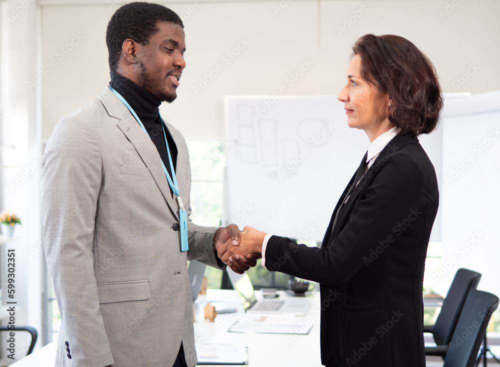 Multiracial businessman shaking hands with caucasian businesswoman at business meeting. Group of ethnicity diverse businessperson handshake as successful startup project with collaboration Multiracial businessman shaking hands with caucasian businesswoman at business meeting. Group of ethnicity diverse businessperson handshake as successful startup project with collaboration