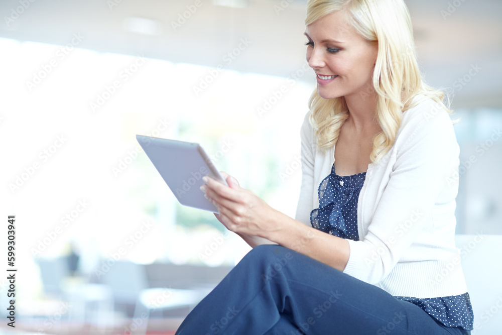Enjoying the perks of technology. A business woman looking at her digital tablet in an office environment. Enjoying the perks of technology. A business woman looking at her digital tablet in an office environment.