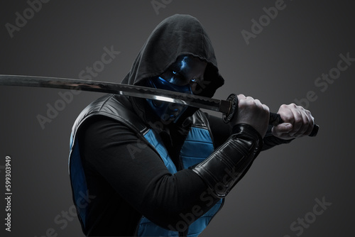 Studio shot of isolated on gray background ice assassin with katana in fight stance.