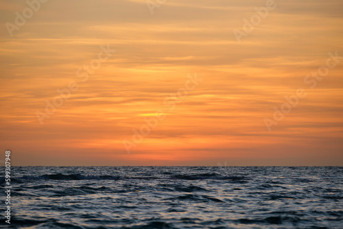 Dramatic red ocean waves at sunset with soft evening sea dark water