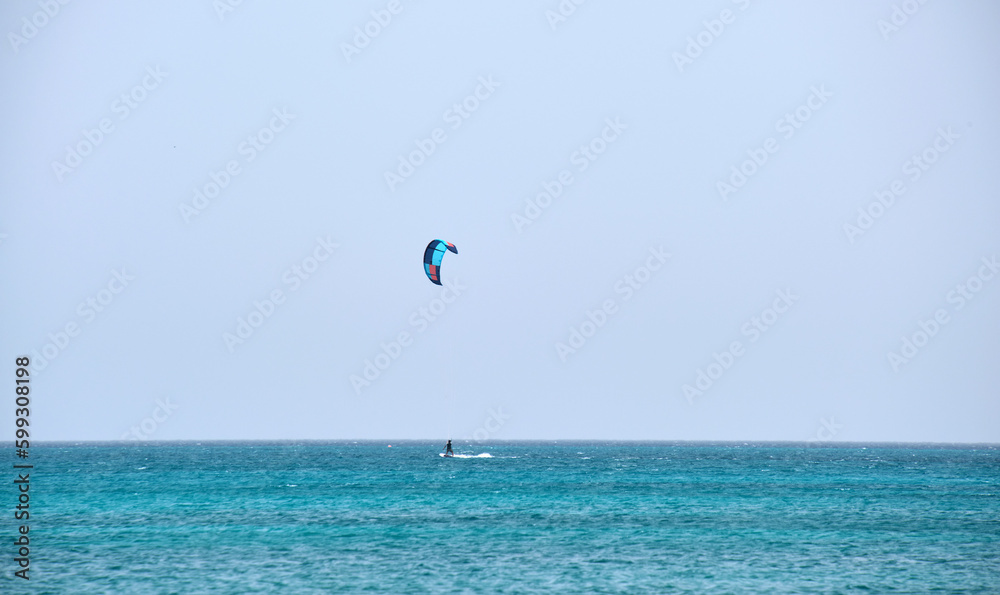 People sportsmen windsurfing and kite surfing in blue ocean water. Summer extreme exotic sport concept