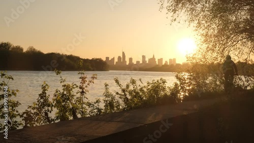 The silhouette of a cyclist against the backdrop of evening Warsaw. A big city at sunset.